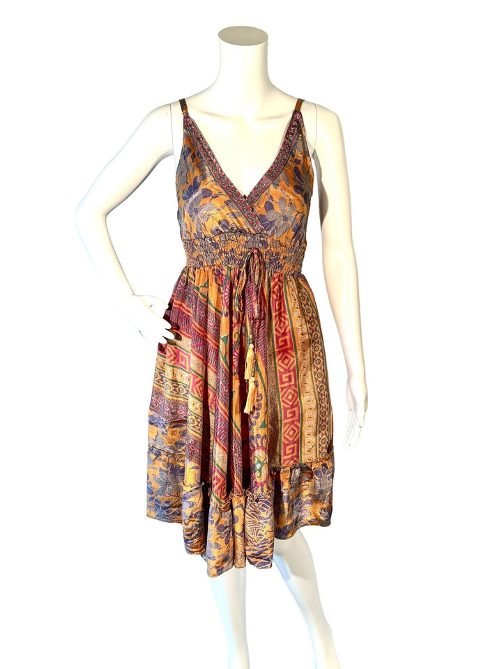 A multicolored, floral patterned dress with a tie-dye effect, displayed on a mannequin.