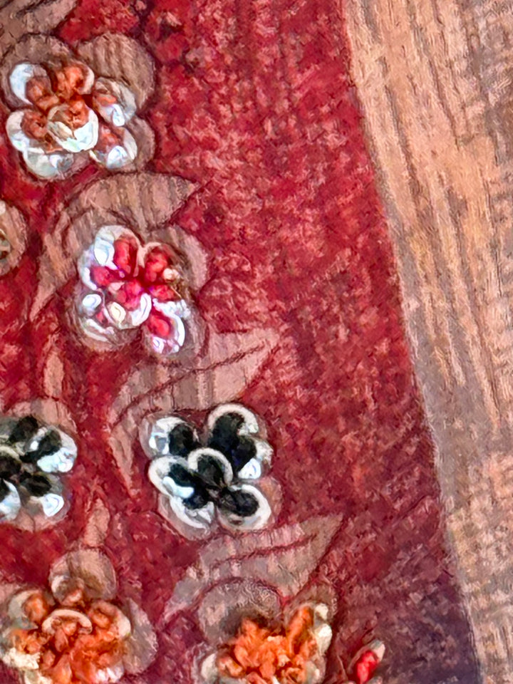 Close up of embroidery on vintage silk in red blue and tan stripe