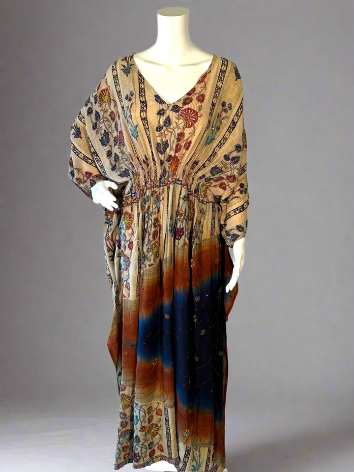 Colorful vintage silk kaftan with floral patterns on a mannequin against a gray background