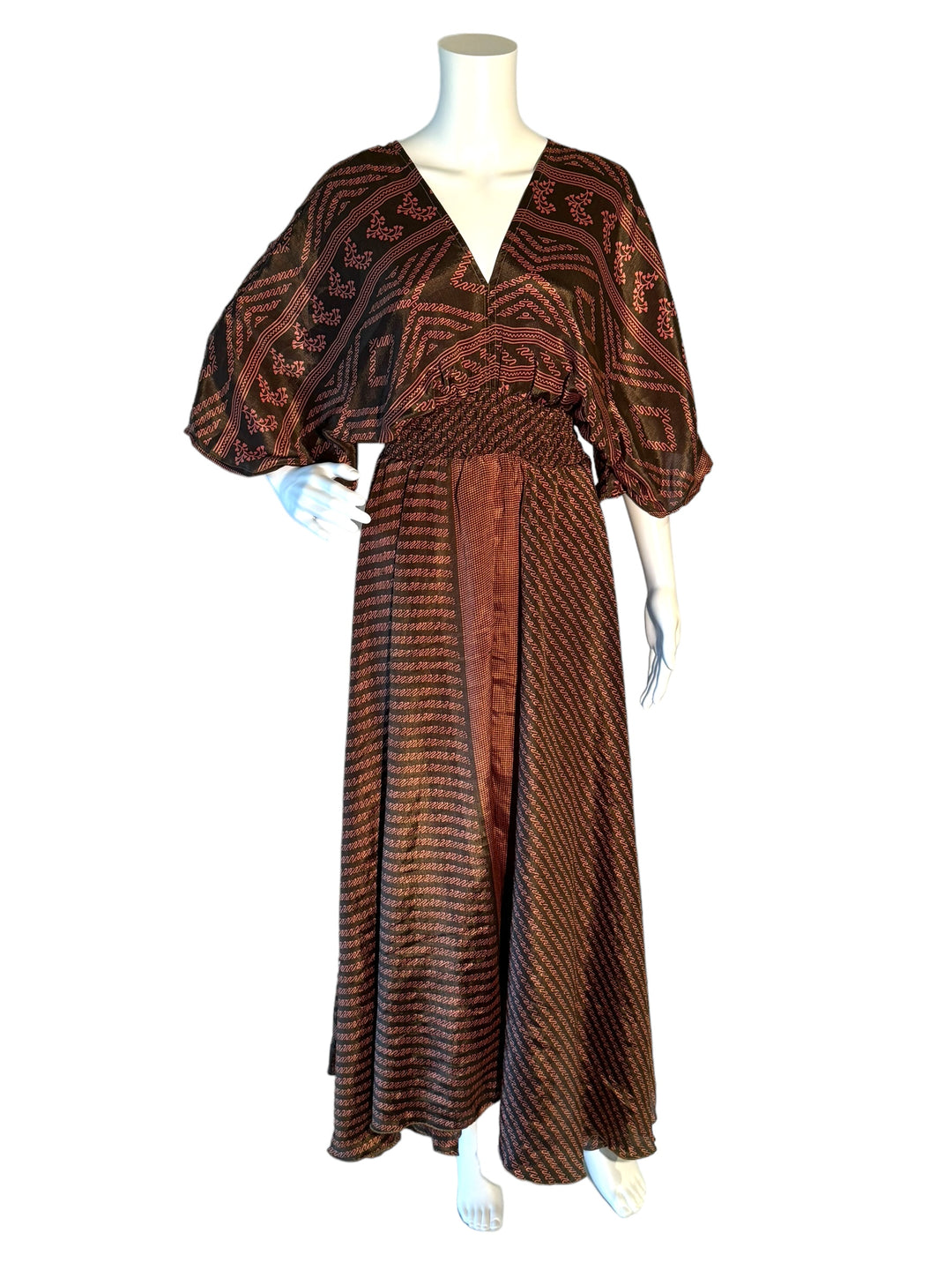 Brown with pink scroll print boho silk blend dress.  Midi length with V neck front and back and tassel tie.  Flattering elastic gathering under bust.