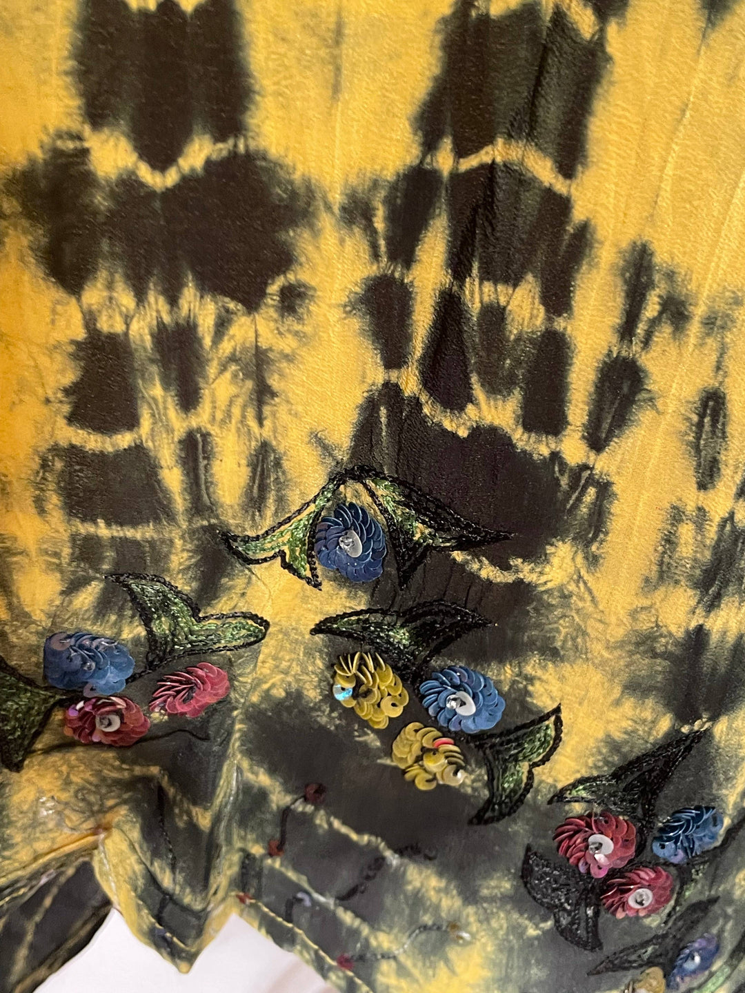 Close up of yellow black dip dye showing embroidery