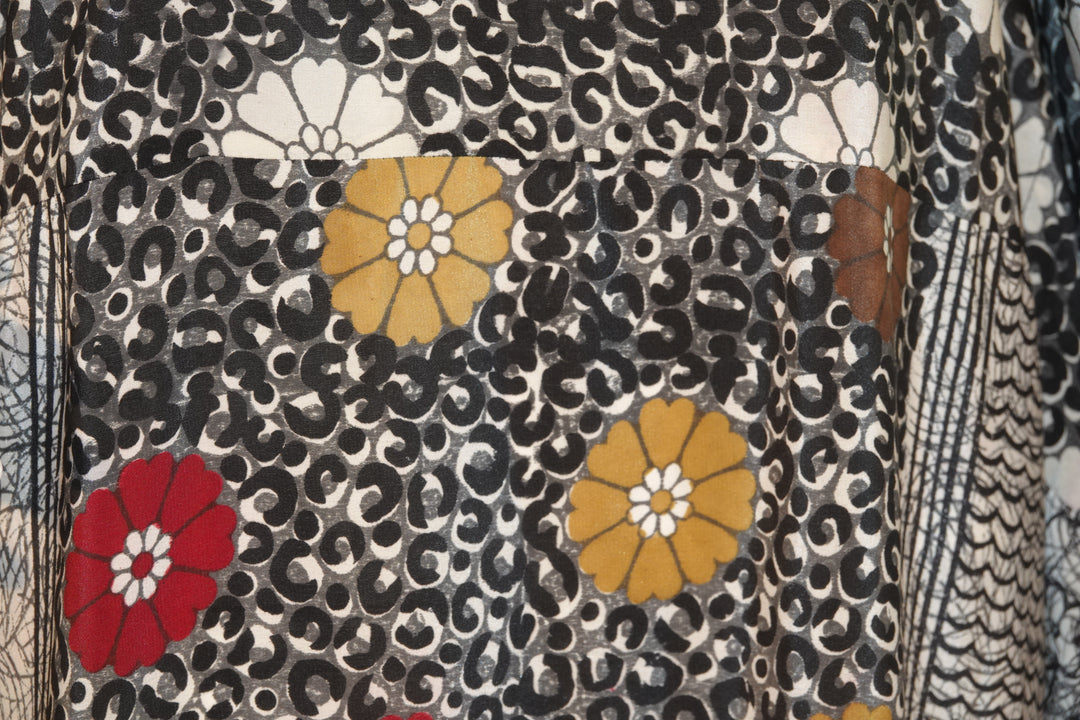 Close-up of a vintage silk with floral pattern featuring red, yellow, and black colors.