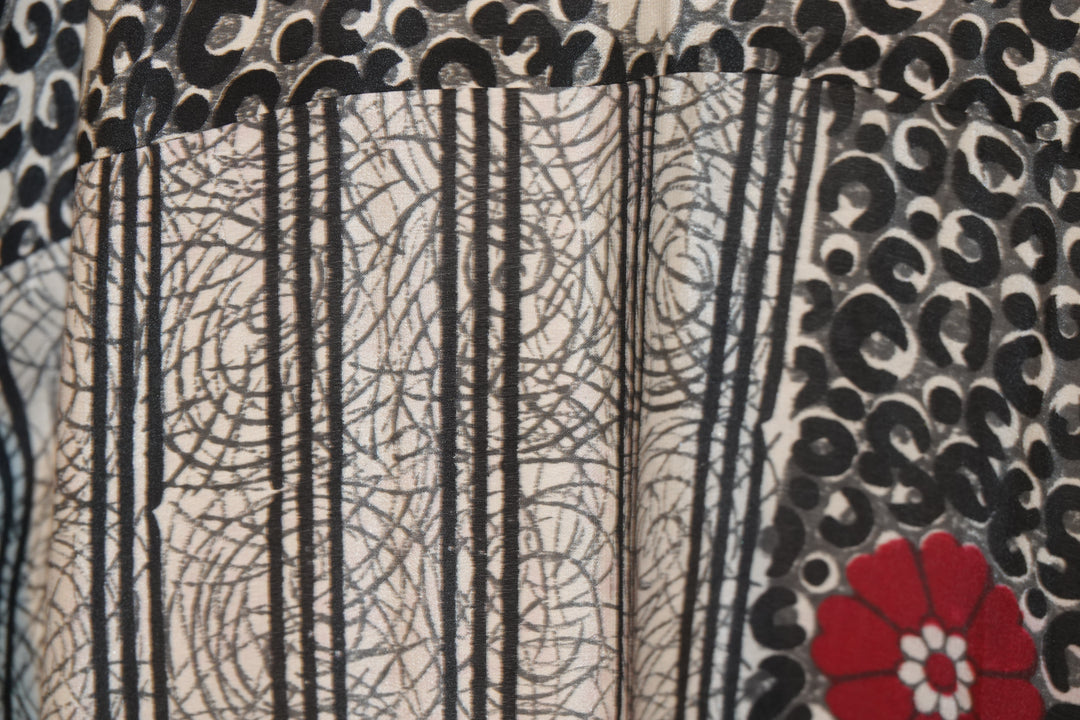 Close-up of a vintage silk with intricate patterns and a red flower design.