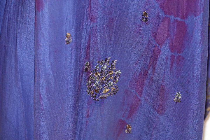 Close-up of a blue dip dyed vintage silk with embroidered floral patterns