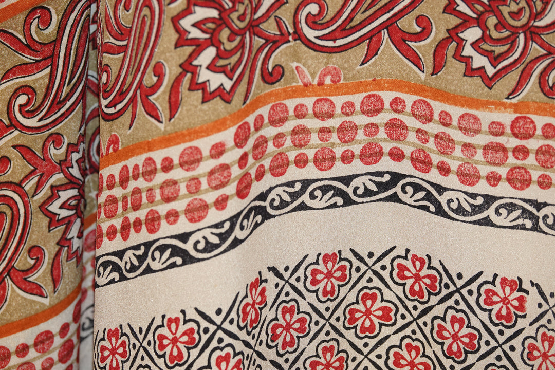 Close-up of patterned vintage silk with red, black, and beige design