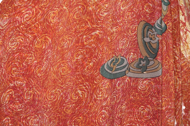 Decorative vintage silk with swirling pattern and embroidered elements on a red background
