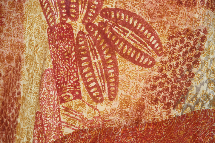 Close-up of a vintage silk in red, orange and gold floral pattern.
