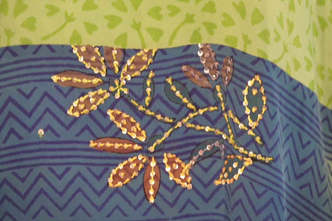 Close up of vintage silk with leaf patterns on a blue and green background
