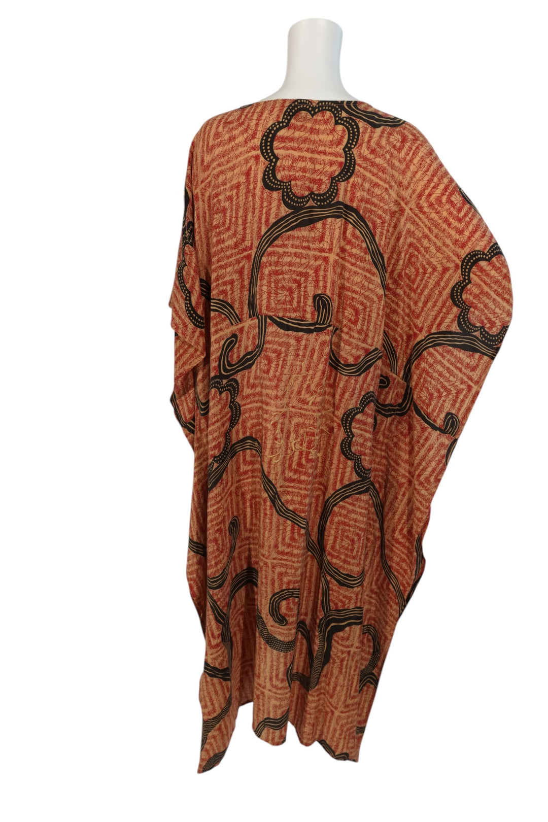 Red and black  patterned vintage silk kaftan on a mannequin against a white background