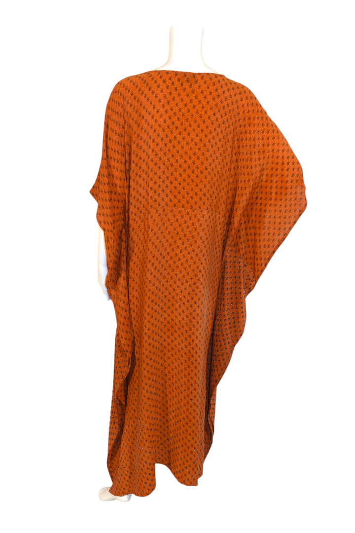 Orange patterned vintage silk kaftan draped over a mannequin on a white background