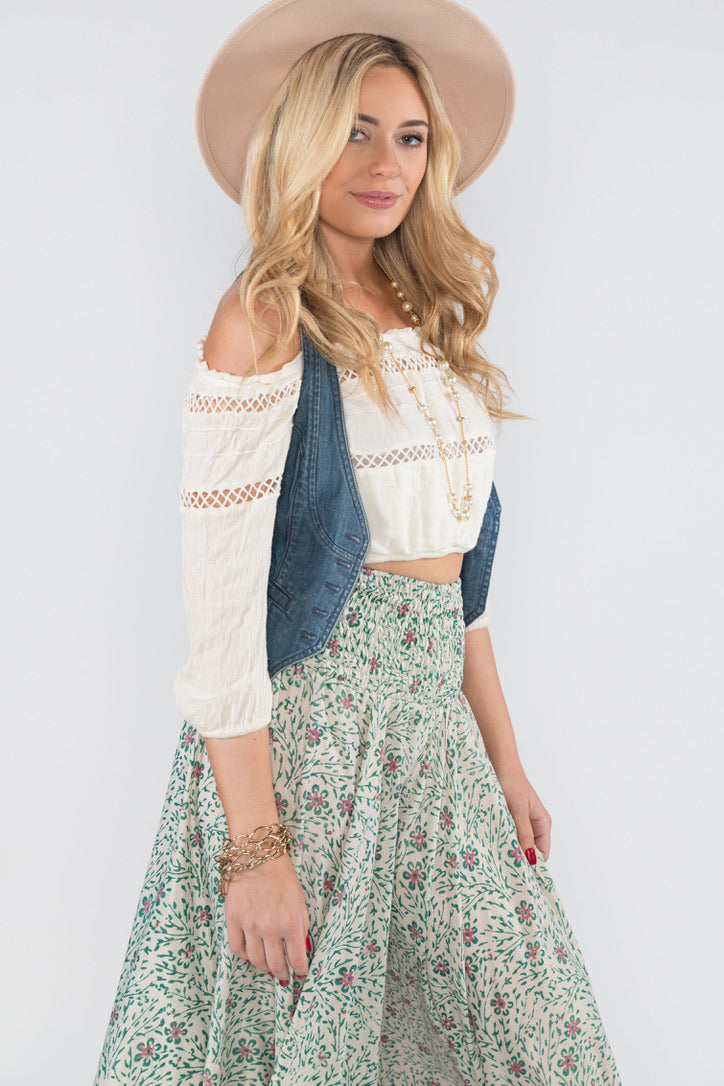 Model wearing vintage silk palazzo white with purple and blue flowers and a hat, white top and denim vest