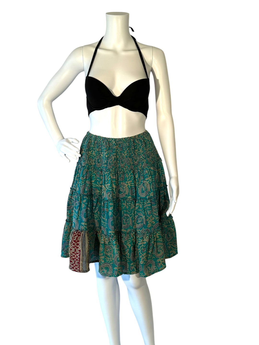 Mannequin wearing gather elastic waist vintage silk tiered skirt in blue green with gold print and pop of red border