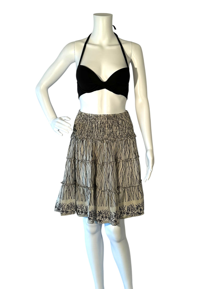 Mannequin wearing vintage silk gathered elastic short tiered skirt in black and cream print