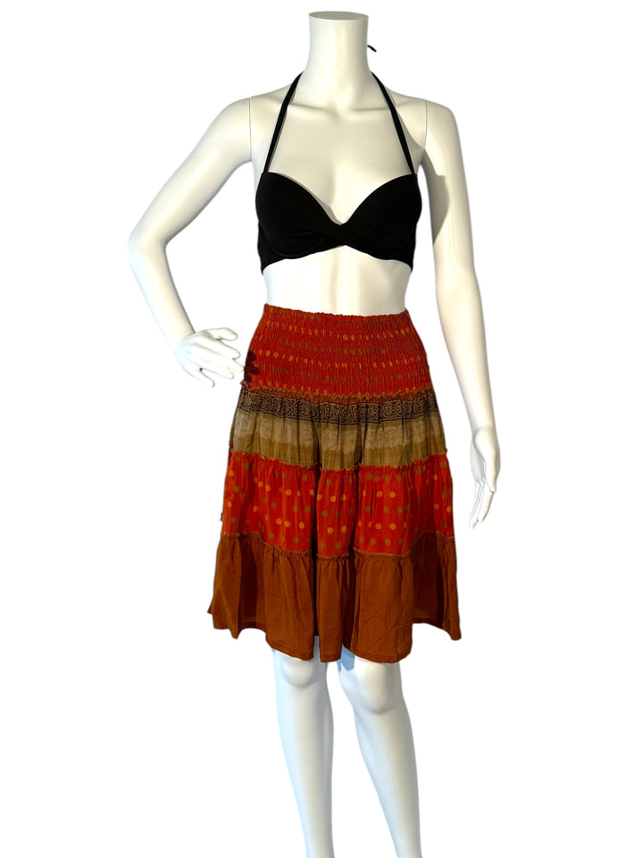 Mannequin wearing vintage silk gathered elastic short tiered skirt in orange with tan and brown print