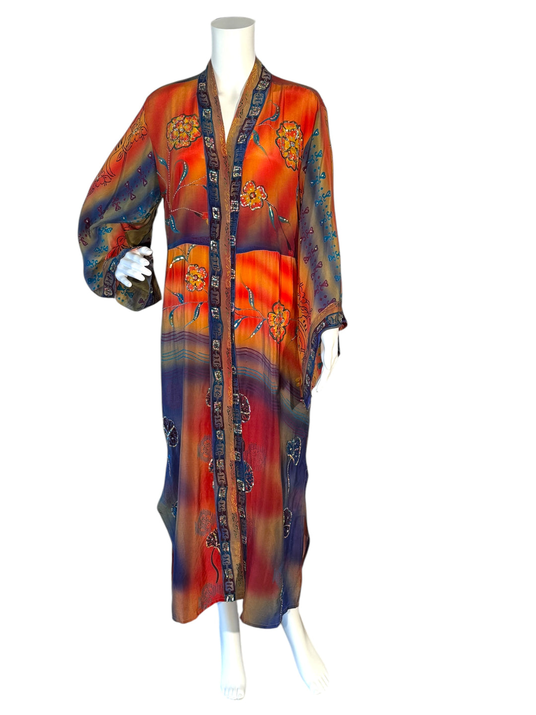 Front view of brightly colored vintage silk kimono in orange, red and blue with large flowers and colorful sequins and embroidery