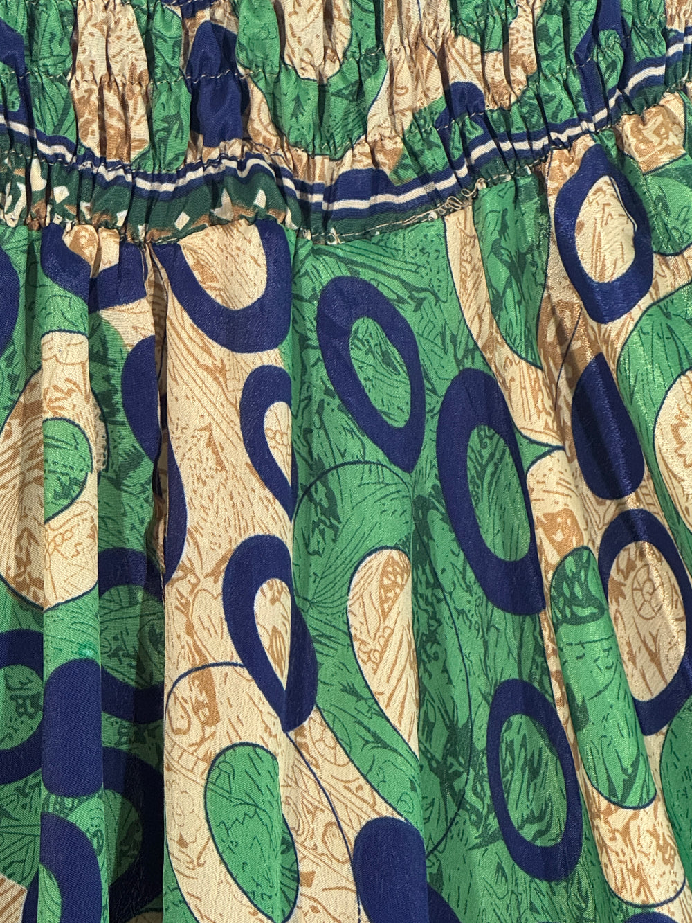 Close-up of a patterned vintage silk blend with green, blue, and beige colors.