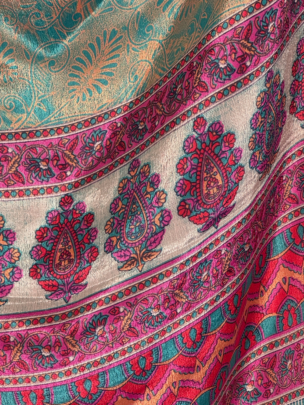 Close-up of a colorful blue green paisley patterned vintage silk blend.