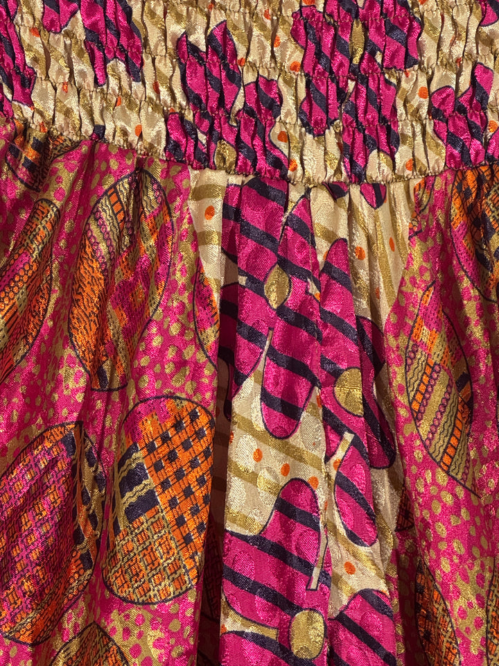 Close-up of a colorful silk blend with intricate patterns in pink, orange, and gold.
