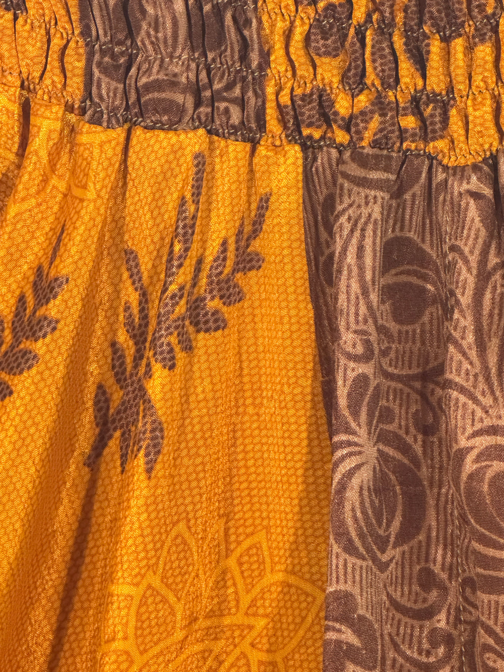 Close-up of a gold silk blend with brown paisley patterns