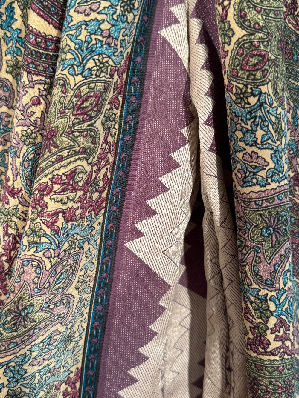 Close-up of patterned silk blend with intricate designs in various colors.
