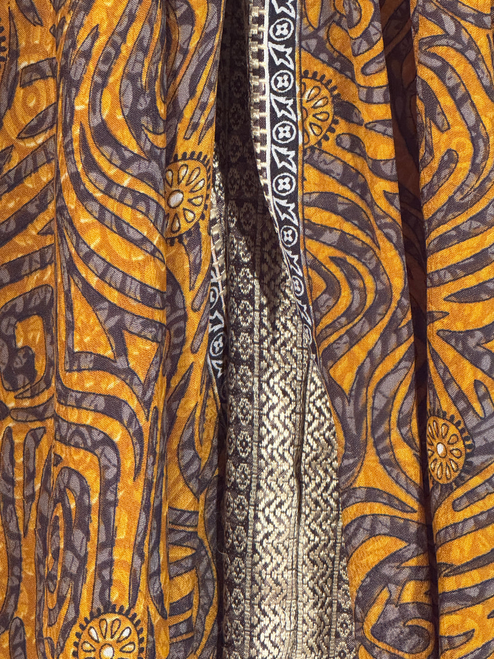 Close-up of patterned vintage silk blend with gold, brown, and black colors.