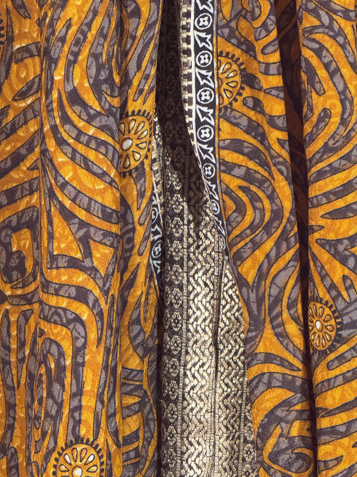 Close-up of patterned vintage silk blend with gold, brown, and black colors.