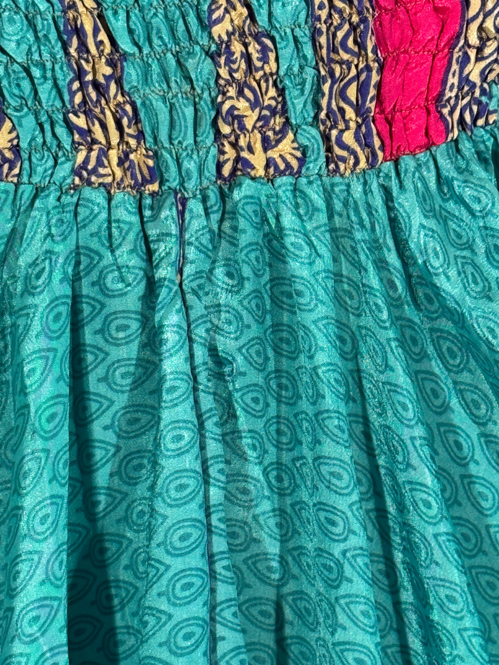 Teal fabric with paisley pattern and colorful border