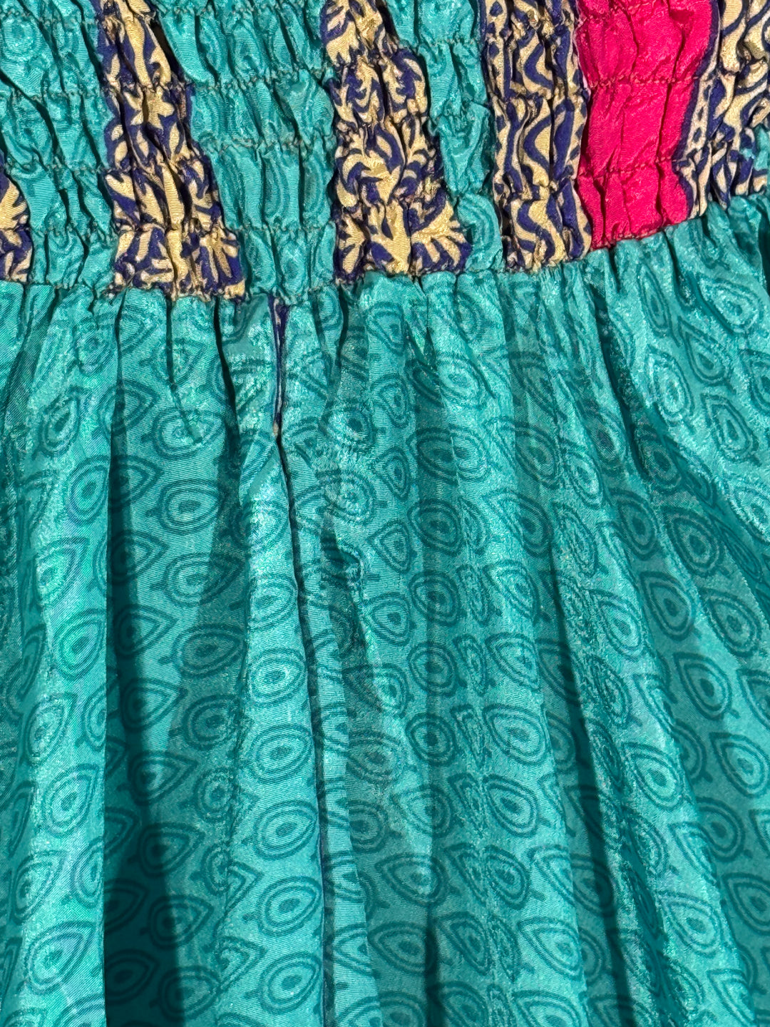 Teal fabric with paisley pattern and colorful border