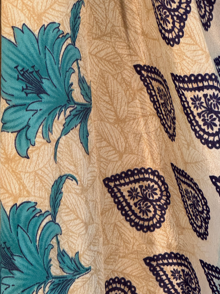 Upcycled silk blend fabric with blue floral patterns on a beige background