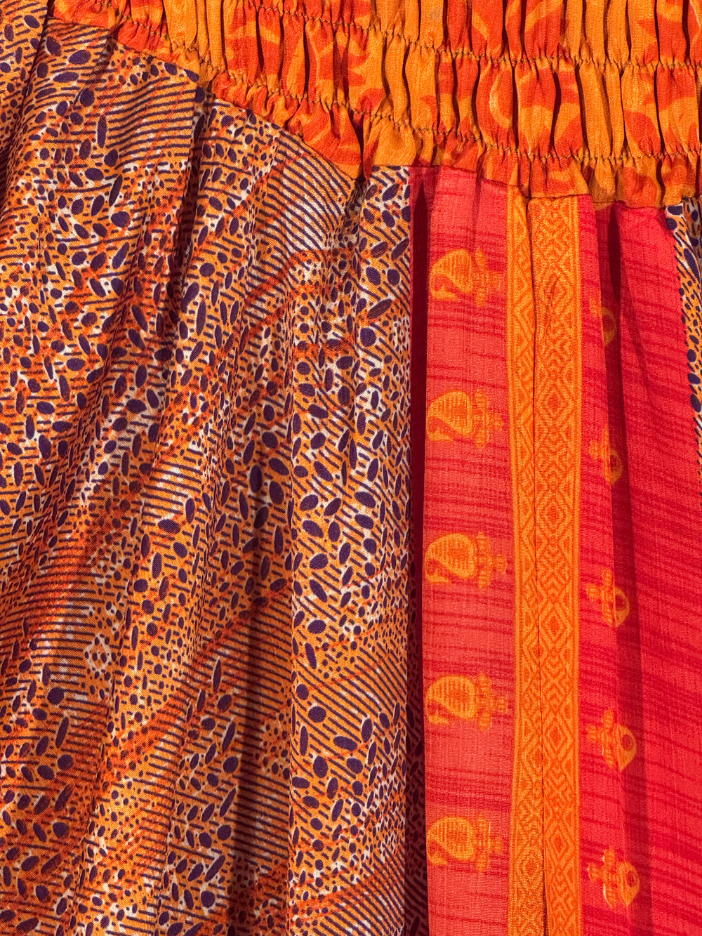 Close-up of patterned upcycled silk blend with orange, red, and purple colors.