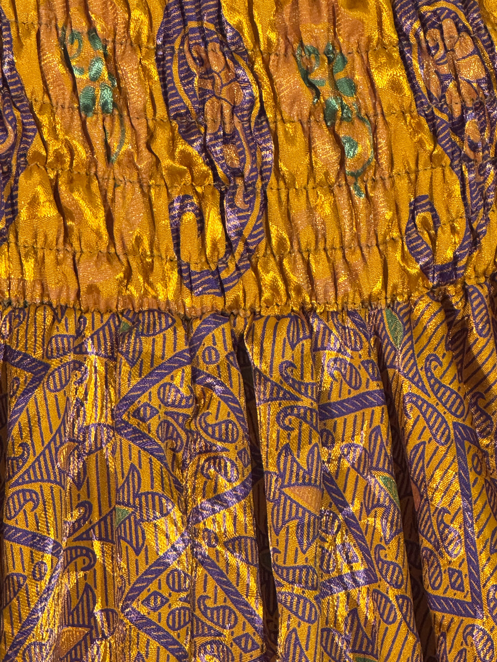 Close-up of gold vintage silk with intricate purple patterns