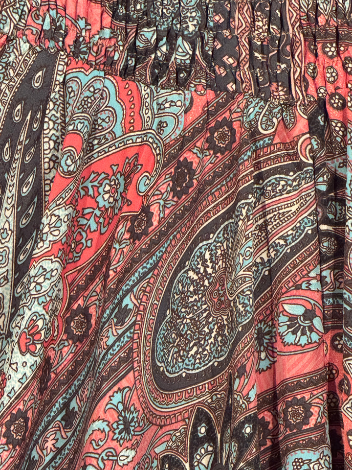 Close-up of silk blend fabric with intricate designs in pink, brown, and blue.