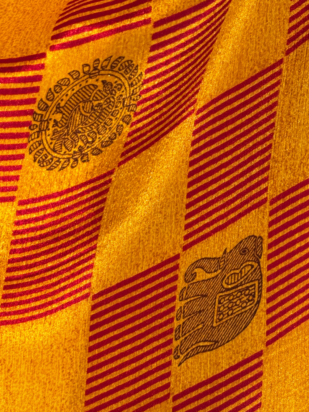 Close-up of a red and yellow silk blend vintage fabric with elephant patterns