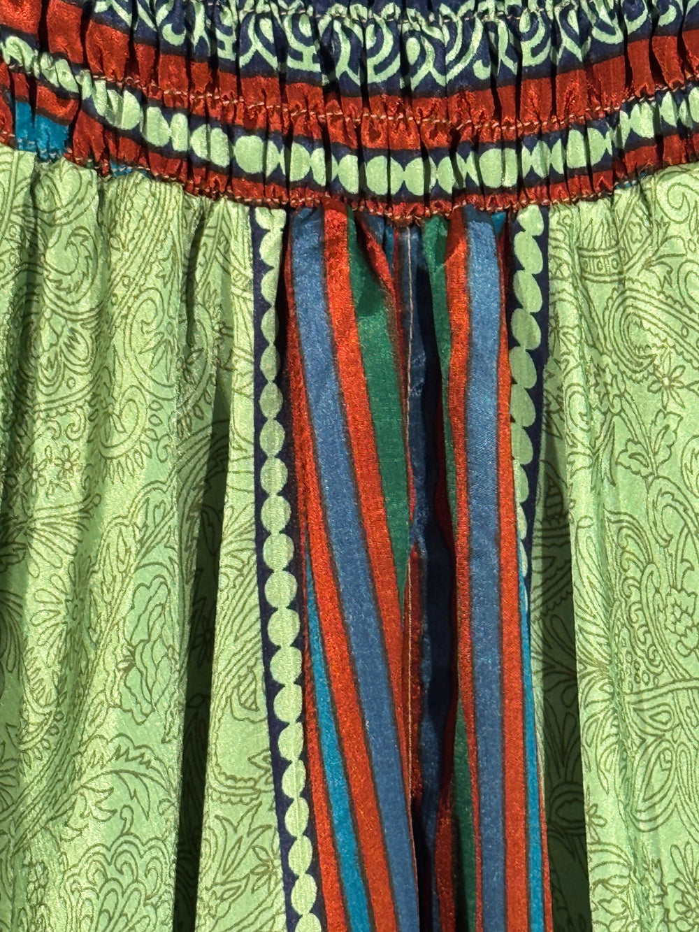 Close up of green patterned vintage silk blend with blue and red