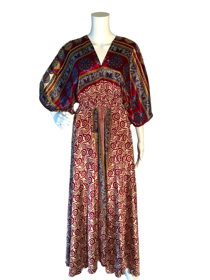 Deep red with cream all over print boho silk blend dress.  Midi length with V neck front and back and tassel tie.  Flattering elastic gathering under bust.