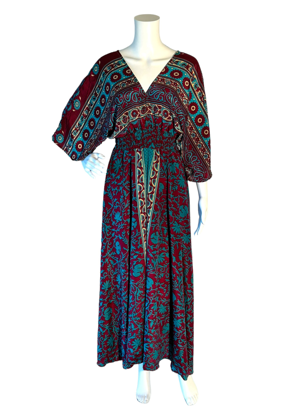 Deep red with bright blue floral print boho silk blend dress.  Midi length with V neck front and back and tassel tie.  Flattering elastic gathering under bust.