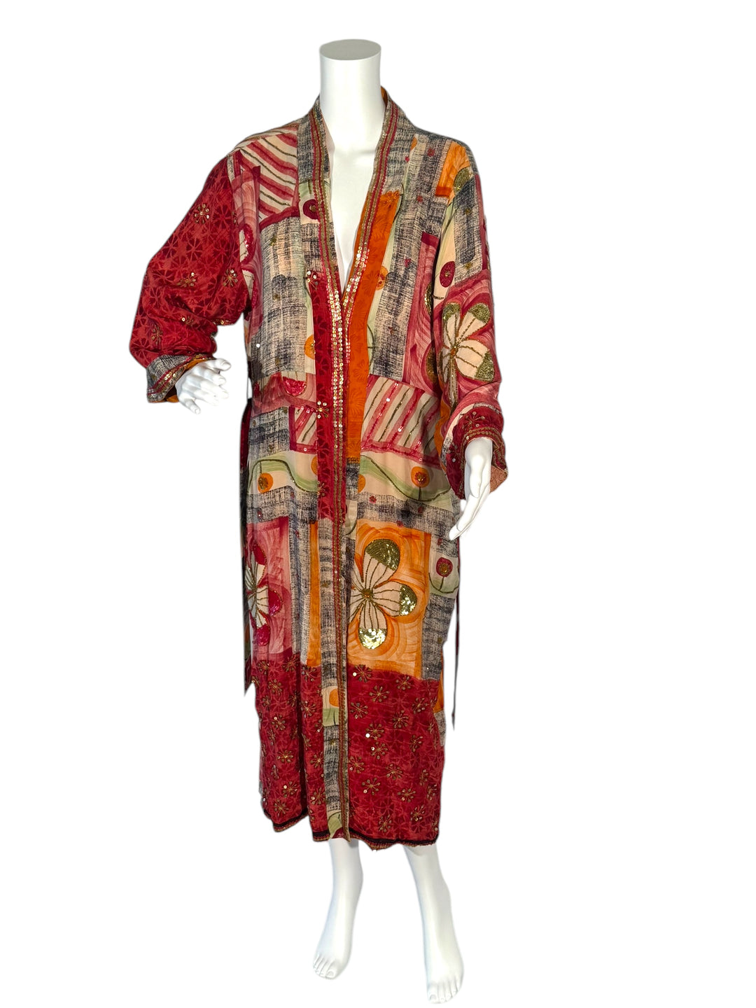 Outside front view of reversible kimono in orange and multi color graphic print with bright sequin embroidery and red borders without tie belt