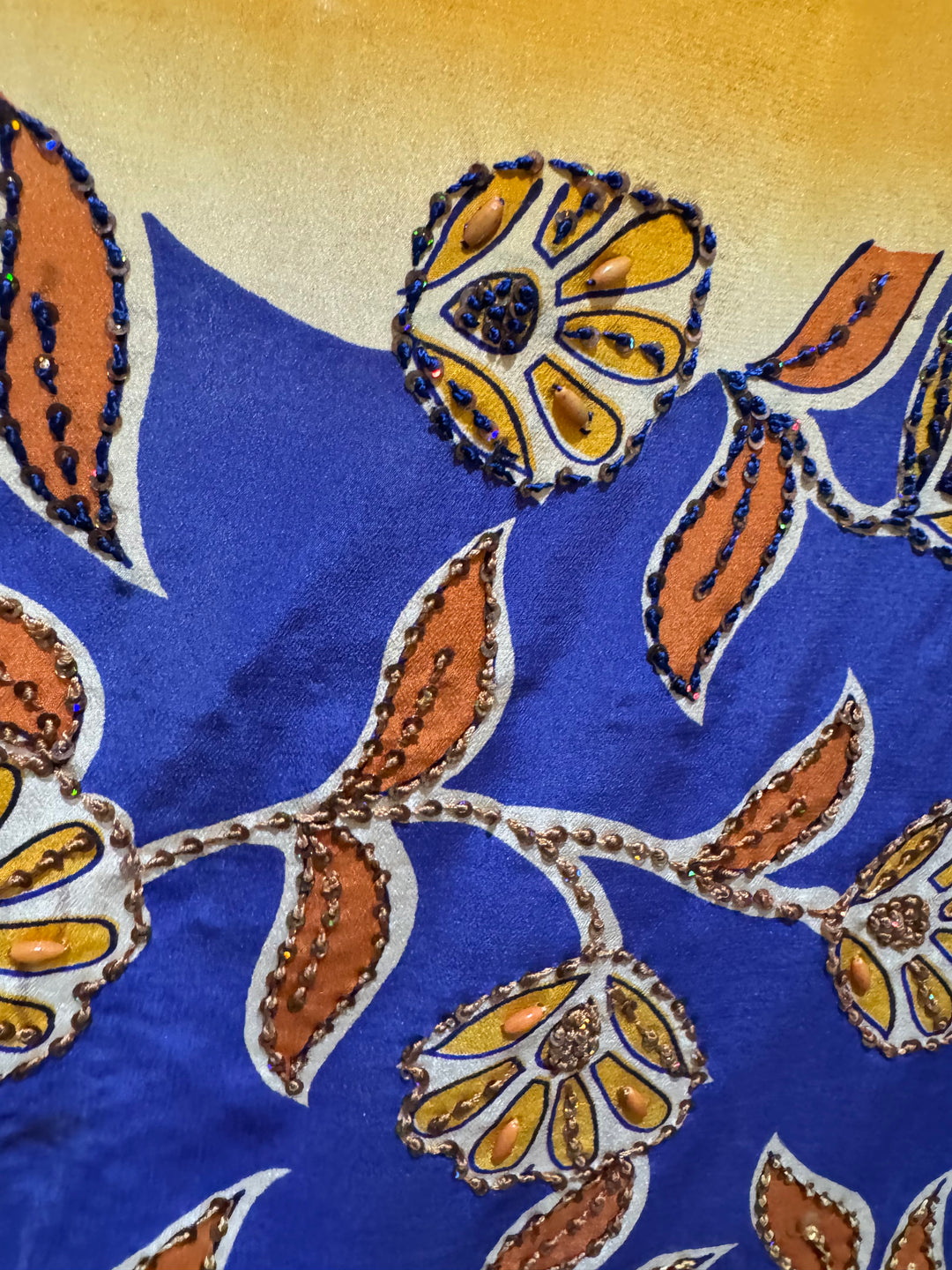 Front view of vintage silk Willow Wrap in orange and blue big floral print with sequins