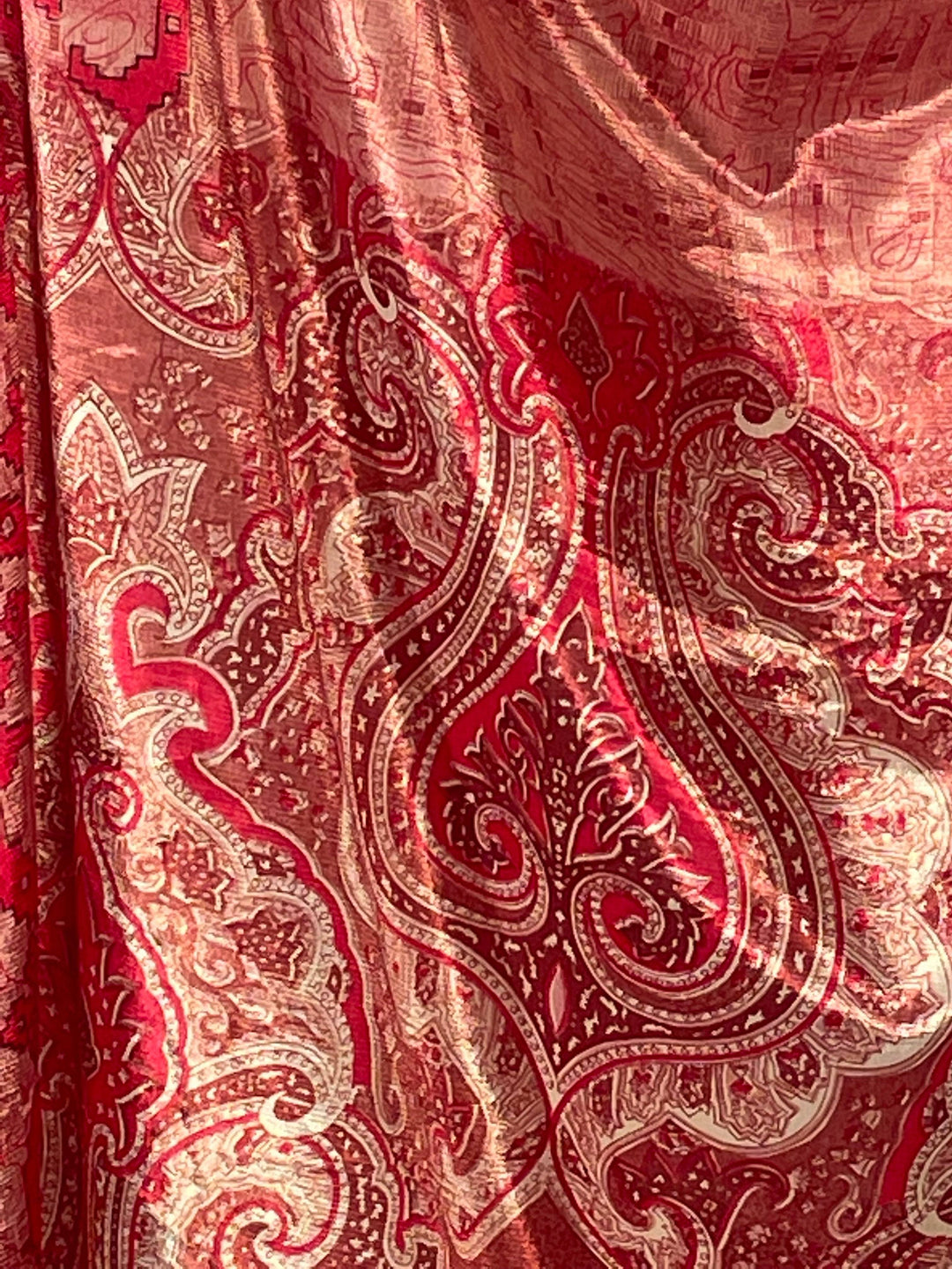 Close up view of red and pink paisley print in sustainable silk