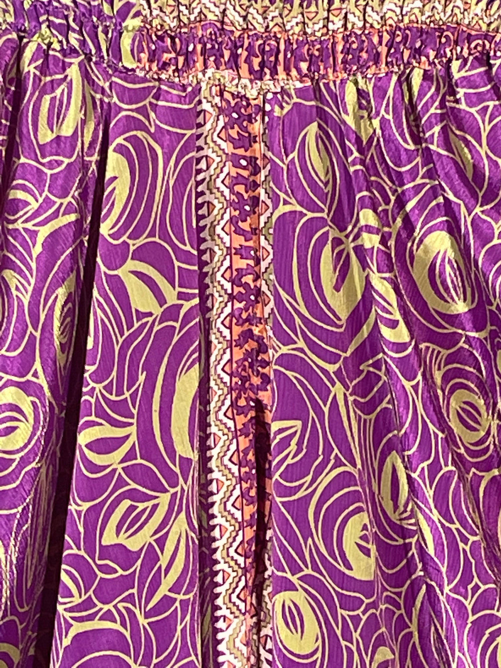 Close up view of purple and gold print in sustainable silk blend