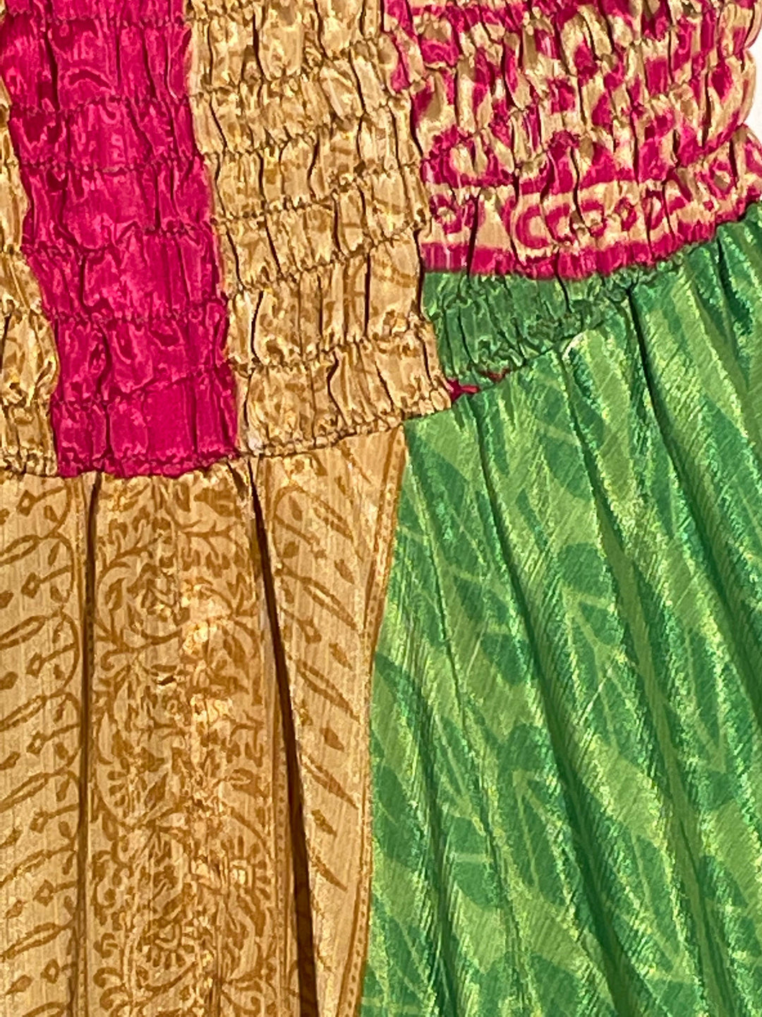 Close up view of green, gold and pink sustainable, reclaimed silk blend